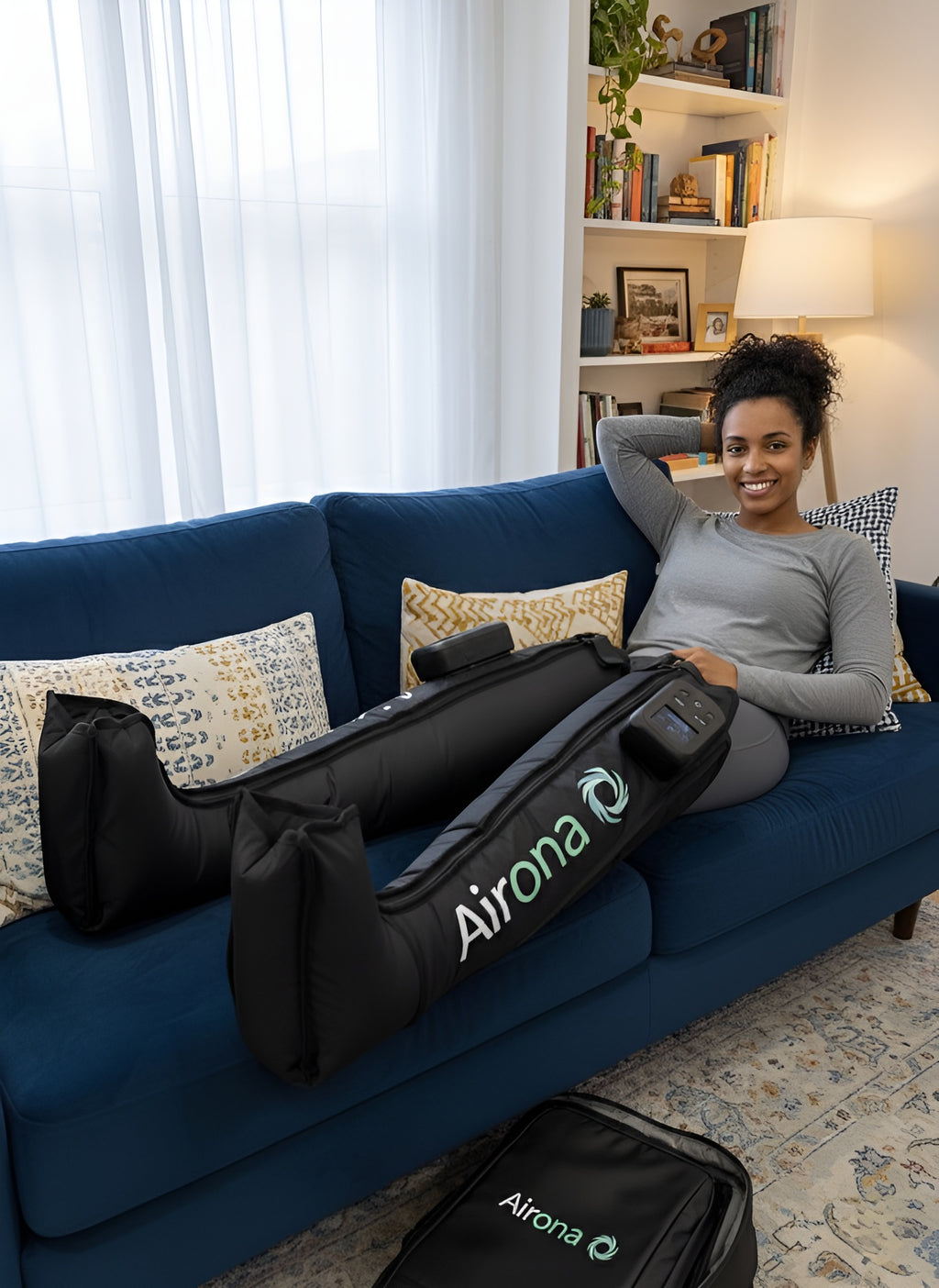 Femme assise utilisant les bottes de pressothérapie sans fil Airona pour la récupération musculaire.