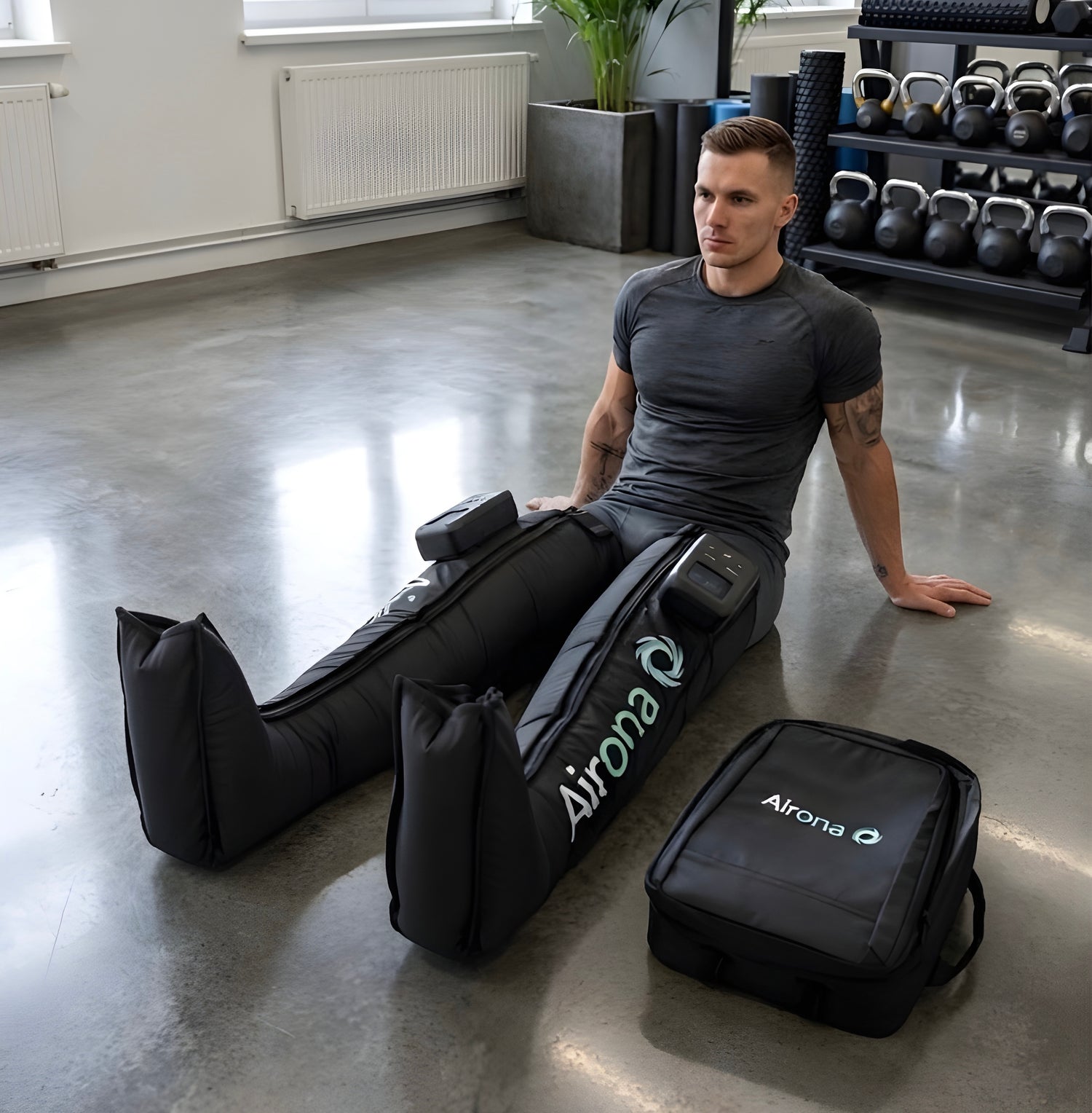 Sportif en séance de récupération avec les bottes de pressothérapie sans fil Airona dans une salle de sport.